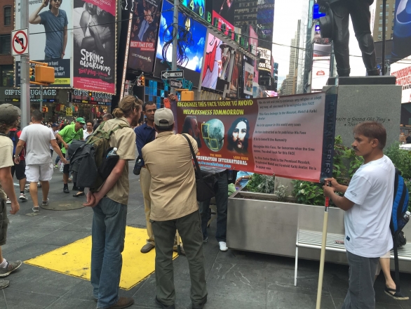 People in Times Square looking at the Divine Signs.