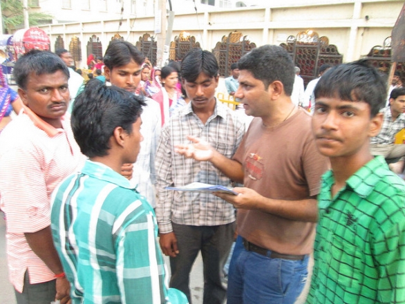 Temple-goers listen to a presenter explaining the method of invocation (Chhatarpur, New Delhi, India).