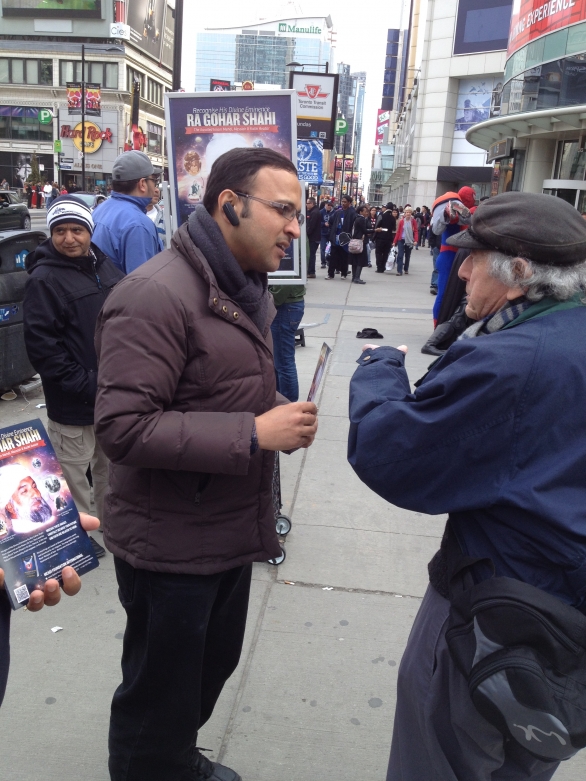 A man stops to learn more about HDE Gohar Shahi in Dundas Square, Toronto.