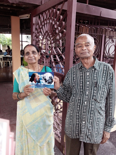 An elderly couple at the temple pose for the camera after receiving the message of Kalki Avatar Ra Gohar Shahi.