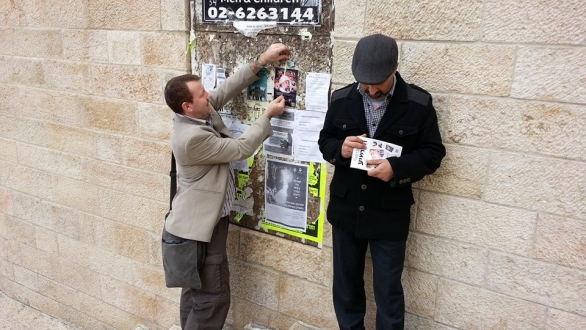 Putting the image of the Messiah Lord Ra Riaz Gohar Shahi on a noticeboard near the Wailing Wall (Jerusalem, Israel)
